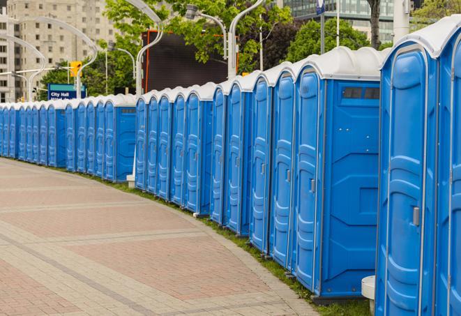 a row of portable restrooms at an outdoor special event, ready for use in Anna